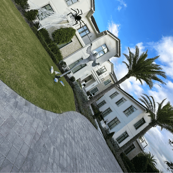 Halloween decorations with spider and spooky elements in a modern front yard.