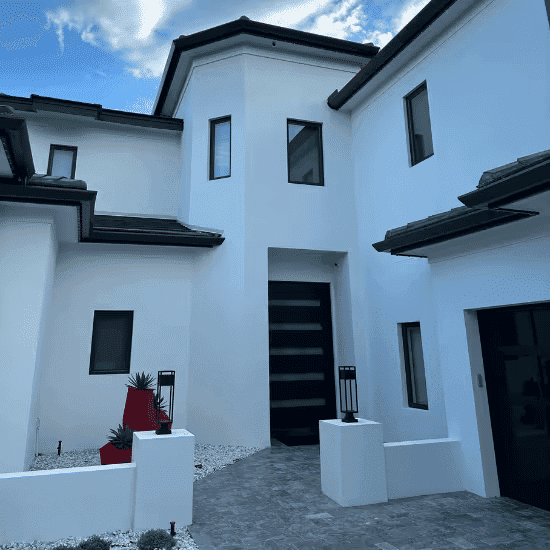 Modern white home with unique architectural design, landscaped garden, and contrasting dark accents.