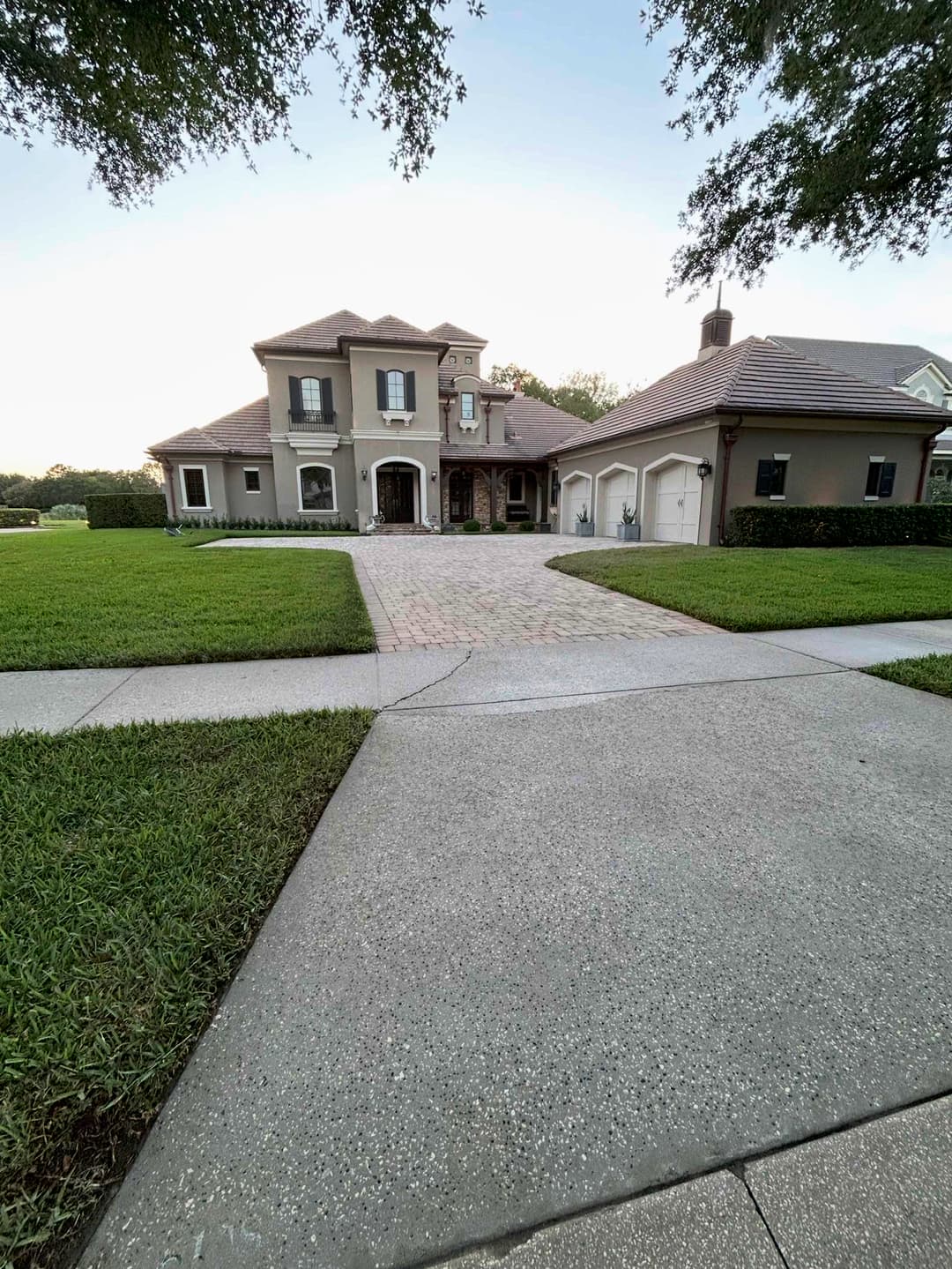 Elegant modern home with a driveway, manicured lawn, and two-car garage in a serene neighborhood.